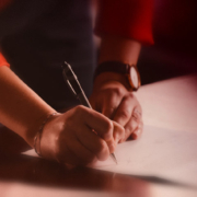 Photo of someone signing a document